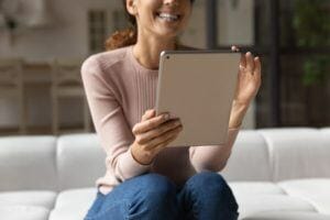 Smiling young lady hold tablet pc use entertainment app
